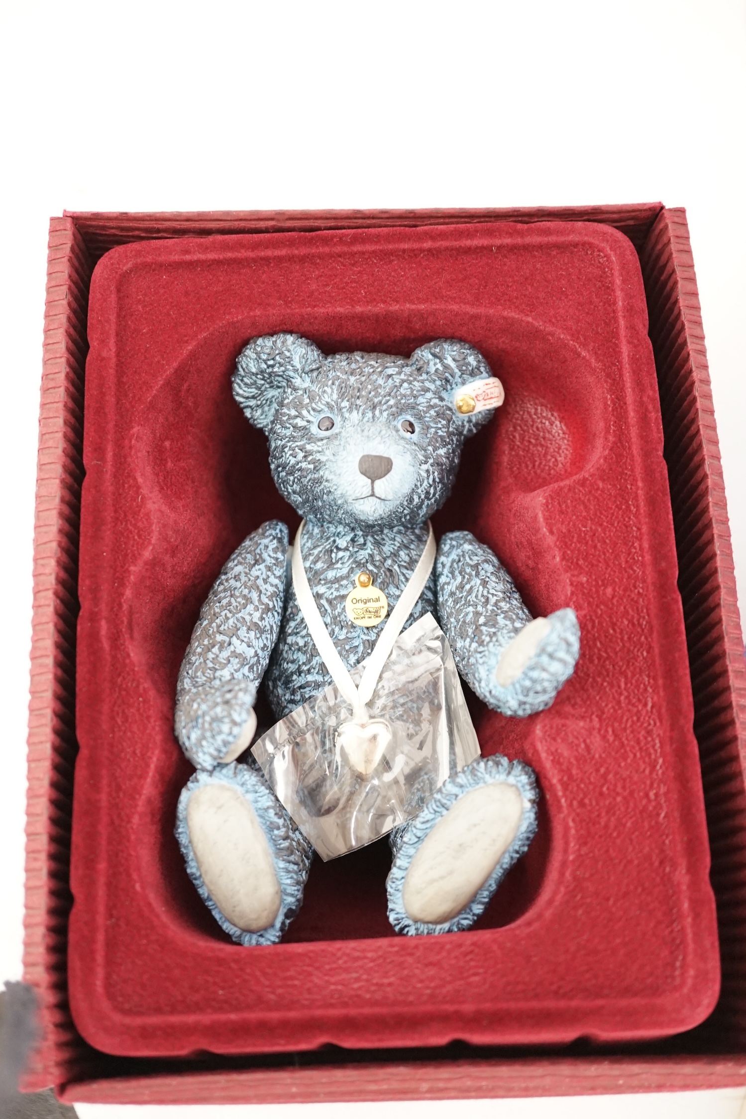 An early Paddington bear, blue jacket, missing hat, a Steiff Ltd. edition lilac bear in box, and a porcelain Pelham puppet in box, good condition